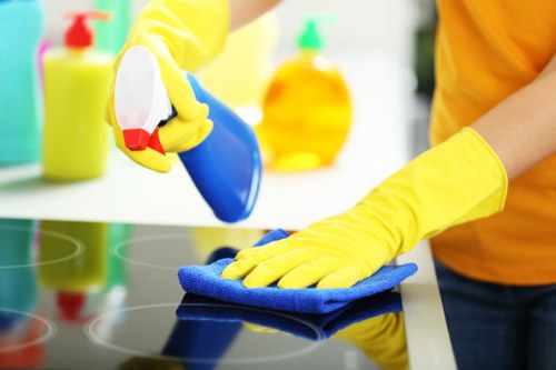 Staff member applying carpet cleaning treatment with protective gear